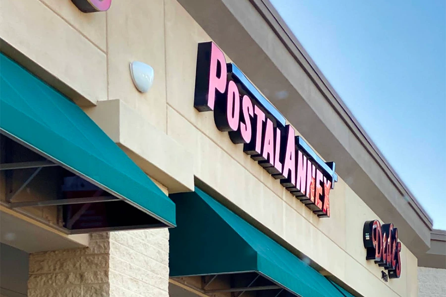 A sign for Postal Annex above a storefront